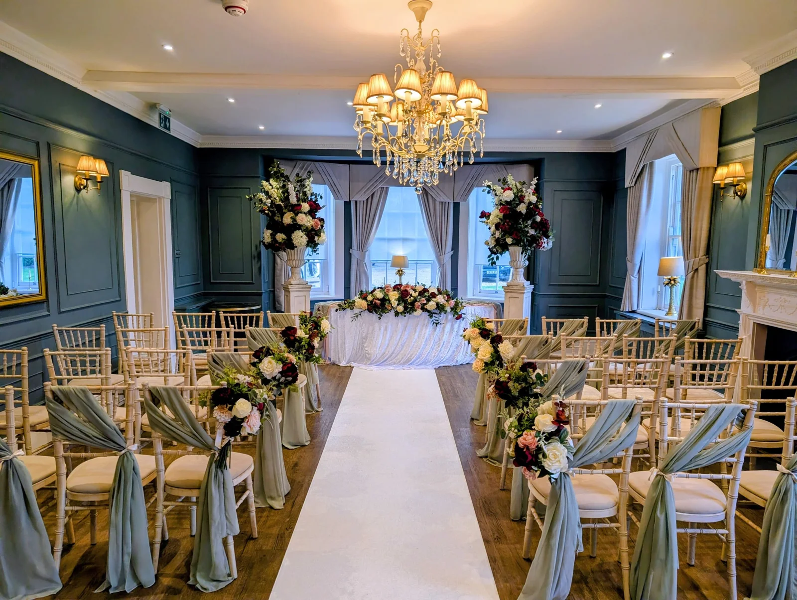 Elegant indoor wedding ceremony setup in De Beauvoir Suite at Downham Hall