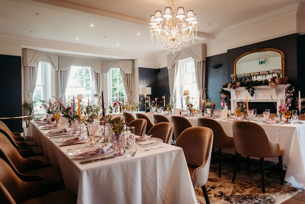 Elegant wedding breakfast setup in De Beauvoir Suite at Downham Hall Essex with long dining table and chandelier