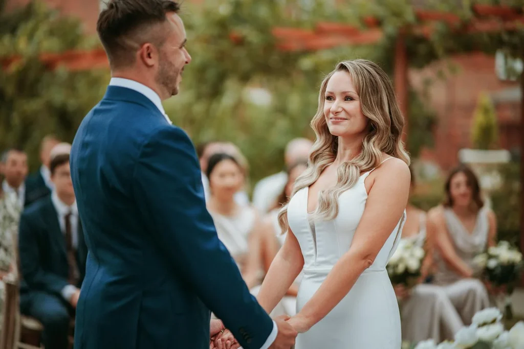 Bride and groom exchanging vows at outdoor wedding ceremony Downham Hall Essex